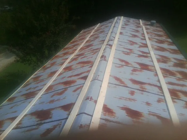 Rusted metal roof panels with new wood purlins before replacement — Storm Damage Roof Repair in Des Plaines by Roofing Brothers