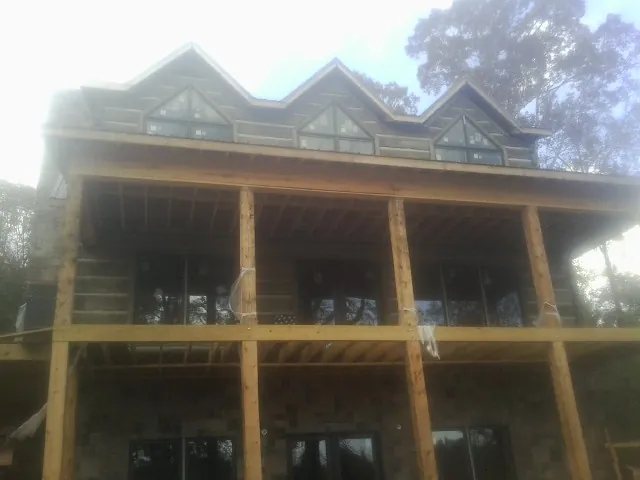Dormers and porch framing on a large log home under construction — Roof Coating work by our crew in Des Plaines